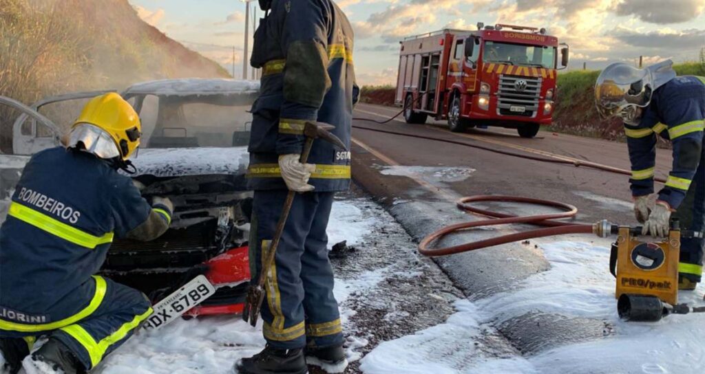 Equipe de bombeiros próximos ao carro, após conter as chamas.