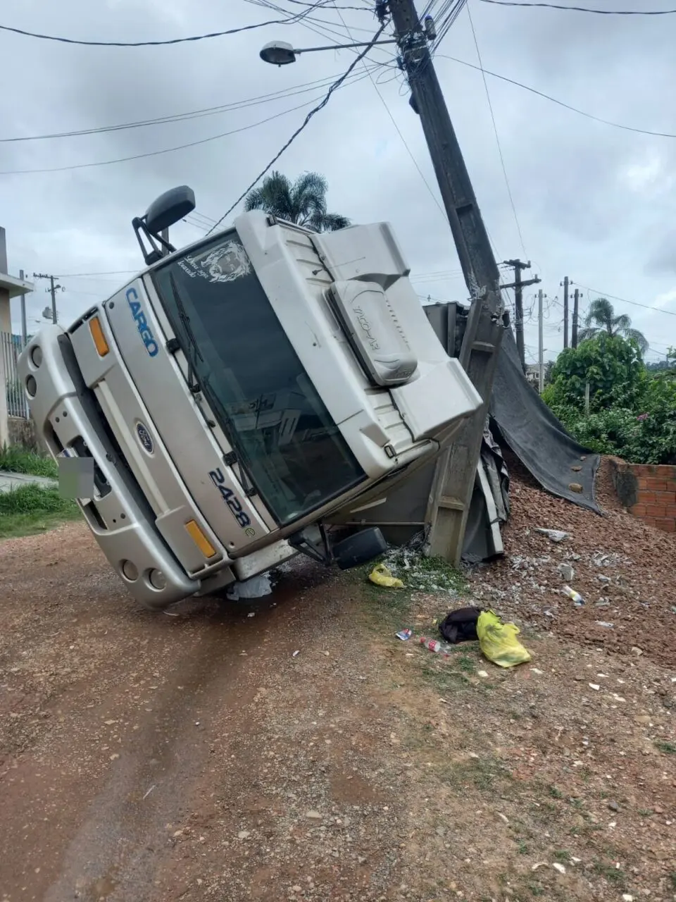 Carro fica destruído após caminhão caçamba  tombar em Ponta Grossa
