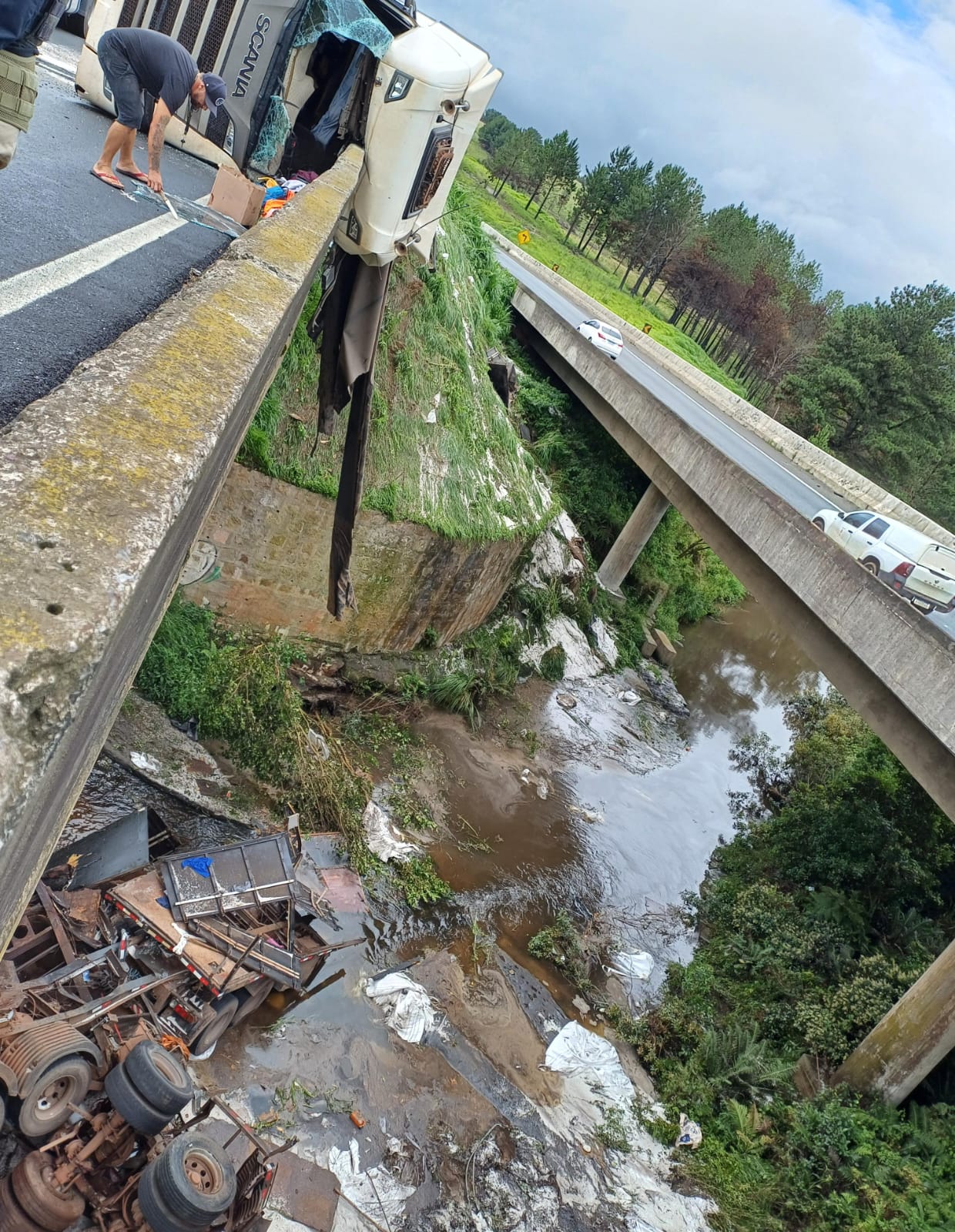 Caminhão tomba e derruba semirreboques em rio na BR-376