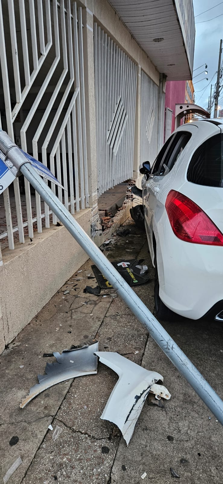 Carro atinge parede de funerária e placa de sinalização em Castro