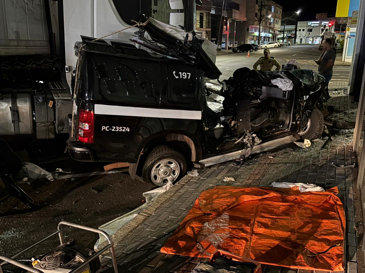 Viatura da Polícia Civil fica prensada após colisão com carreta